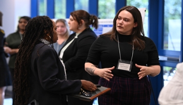 Environmental leadership student Devon explaining project to Provost Patterson.