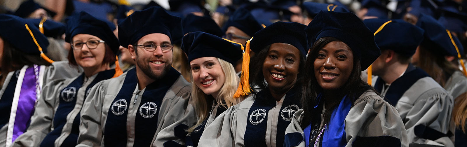 group of five graduate students at graduation