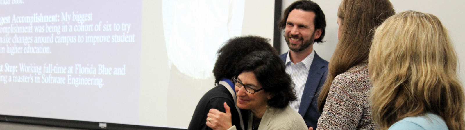 Four Honors faculty members congratulate a graduating Hicks Honors student on his graduation. 