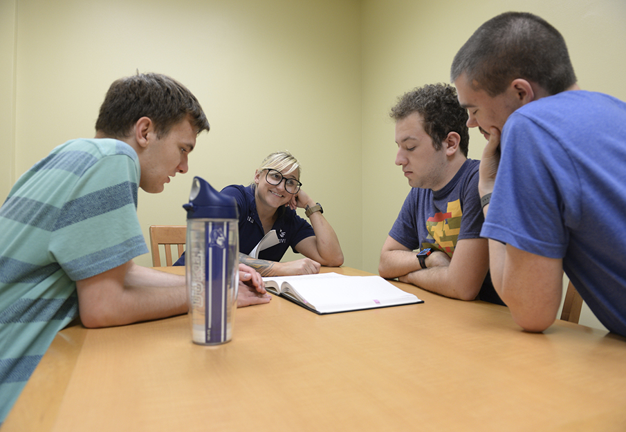 Dr. Rowe and three THRIVE students working together in a classroom