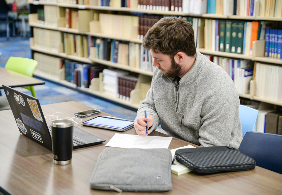 Student working in the library on a laptop