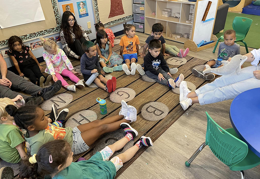 Preschoolers making dolphin tails with their feet