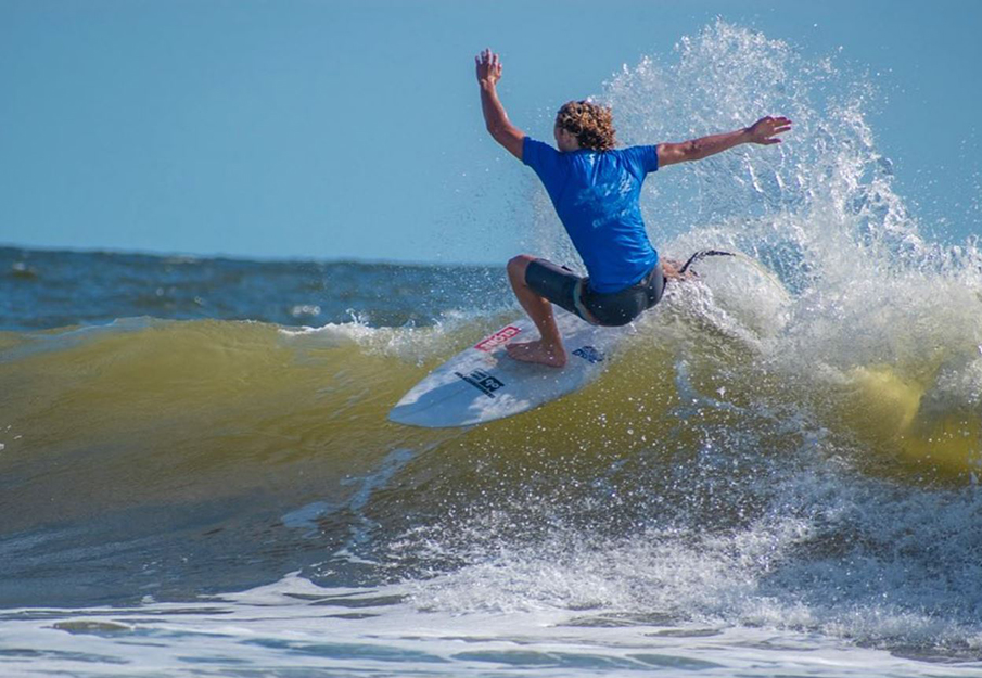 UNF Surf Team member riding a wave; Photo credit to UNF Surf on Instagram 