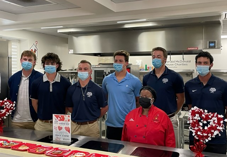 Men's baseball team at the Ronald McDonald House volunteering their time in the kitchen for the cookie decorating party