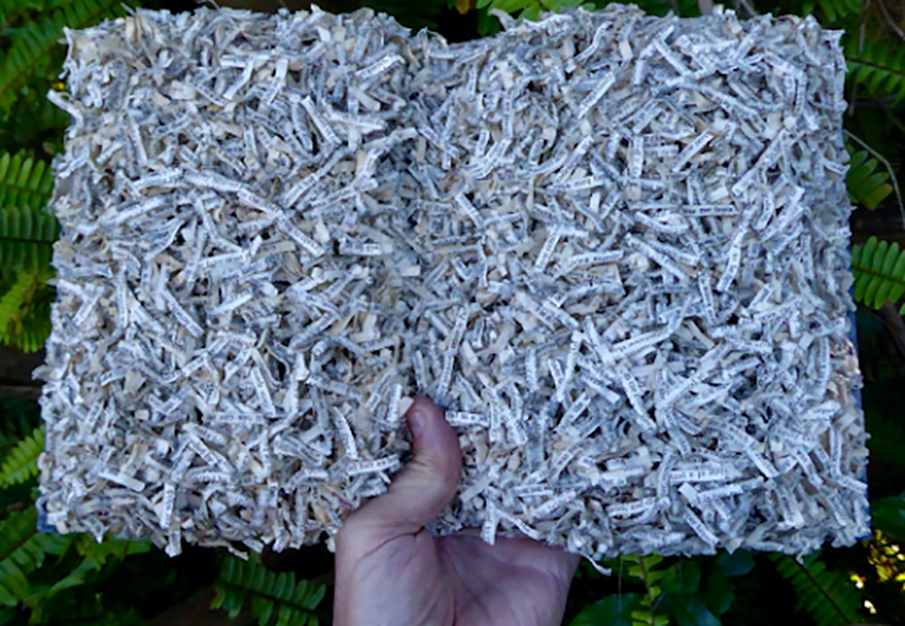 A hand holding up a bunch of strips of paper in the shape of a book