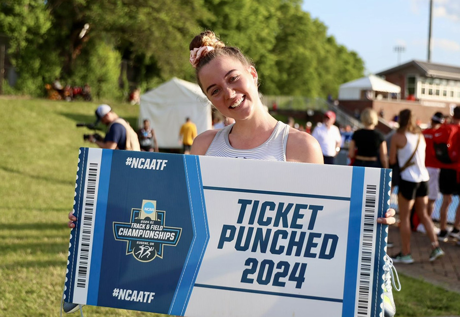 Smilla Kolbe holding a NCAA ticket-shaped sign that reads "Ticket Punched 2024"