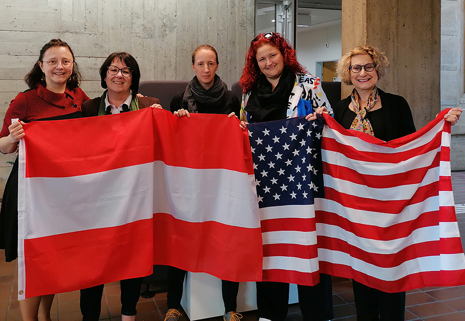 Aleksandra Jama, Birgit Münzer, Eva Sacherer, Dagmar Schnepf and Sherry Shaw holding up an Austrian and an American flag