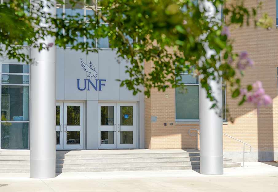 Outside view of a campus building with pink flowers outside