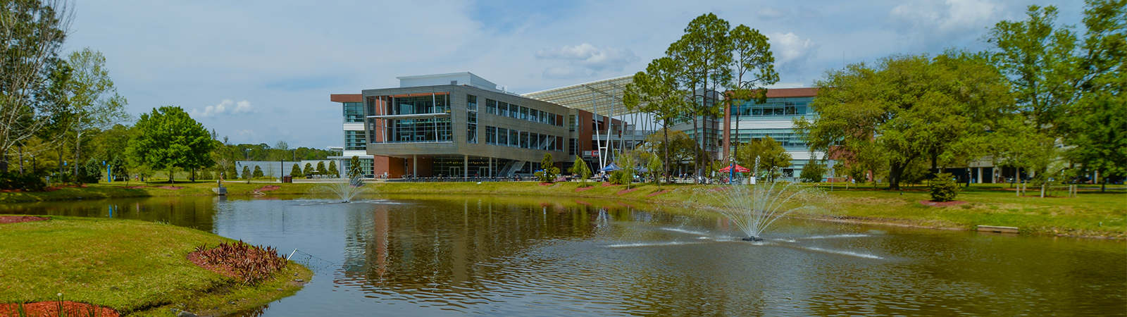 Student Union with lake in front and surrounded by trees