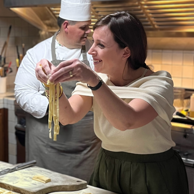 student making pasta in Italy smiling with noodles