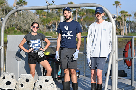 three students on a fishing boat posing