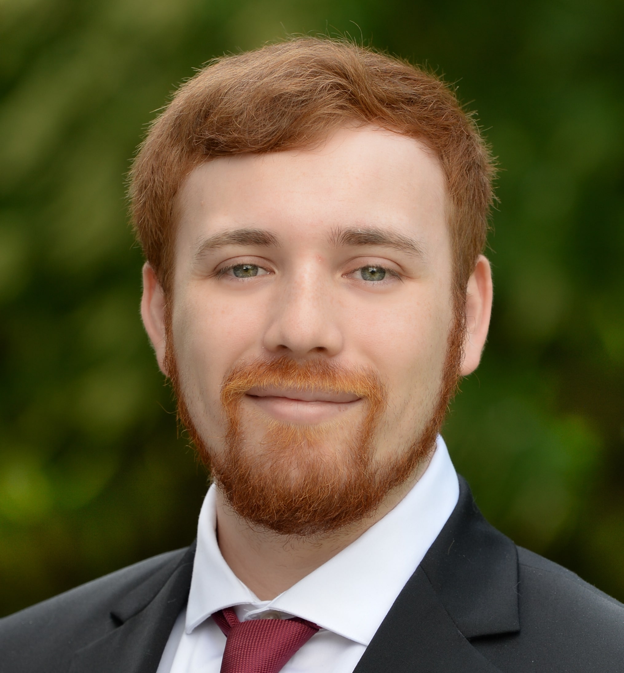 A young man wearing a suit and posing for a photo.