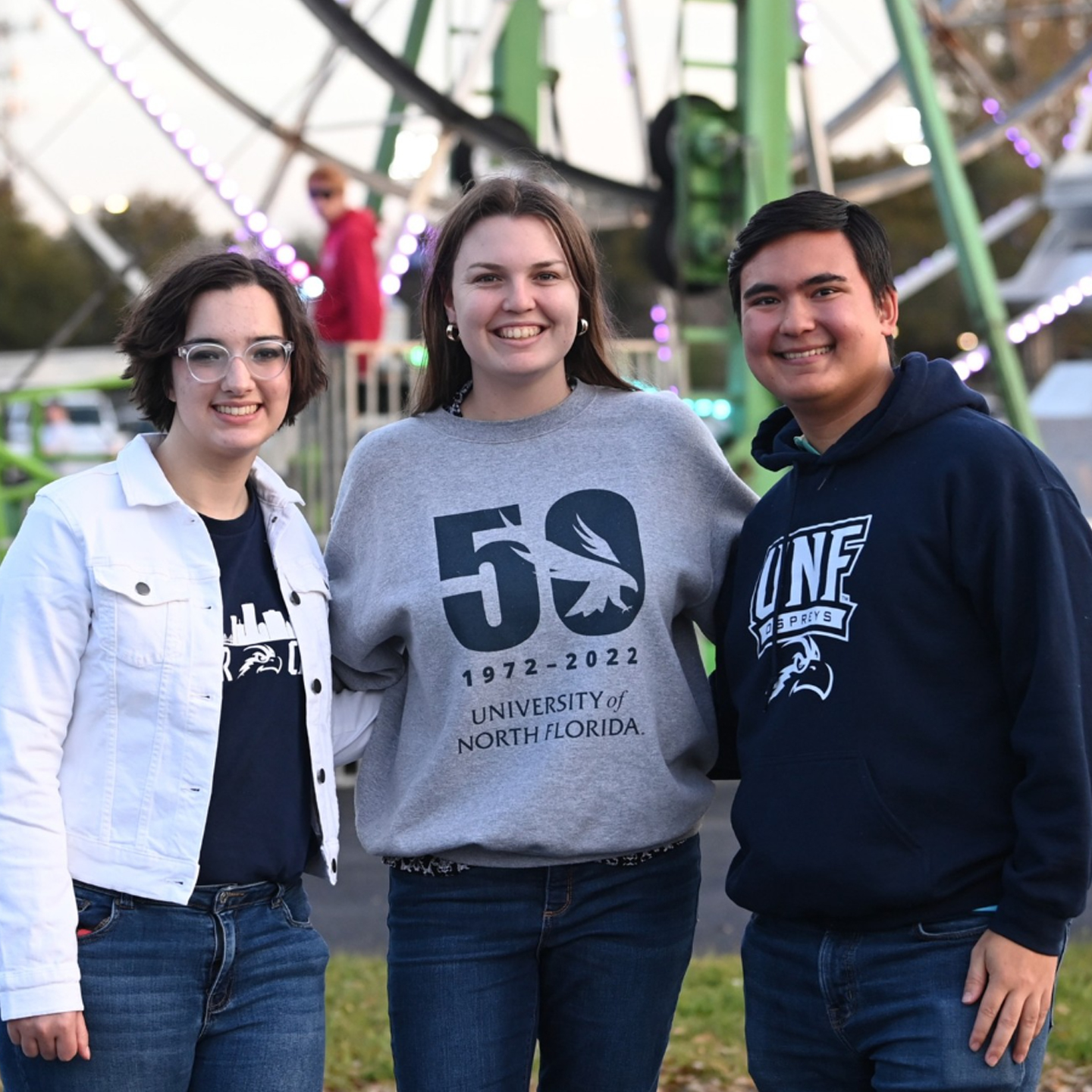 students embracing in front of a ferris wheel 