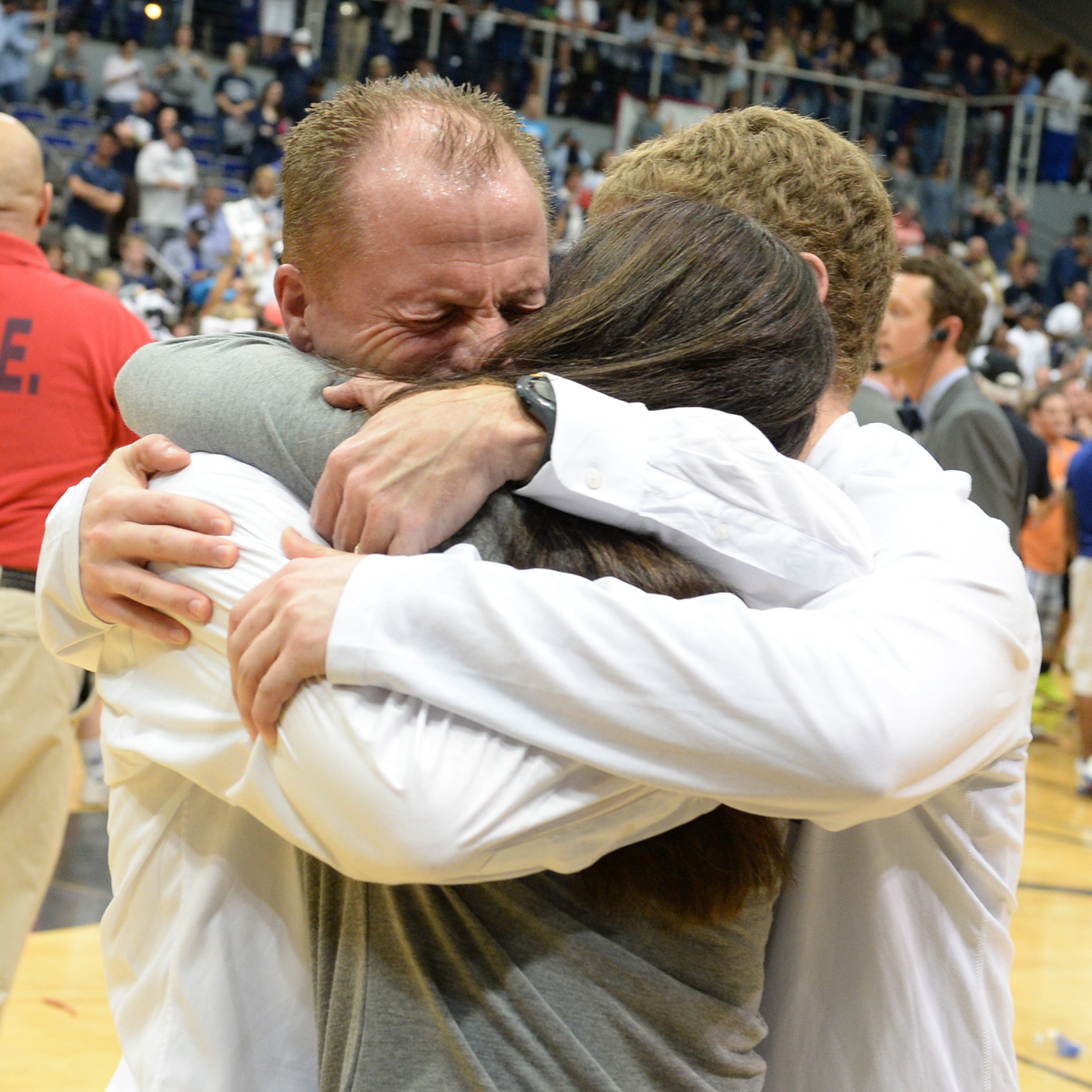 coach driscoll hugging his family on the basketball court