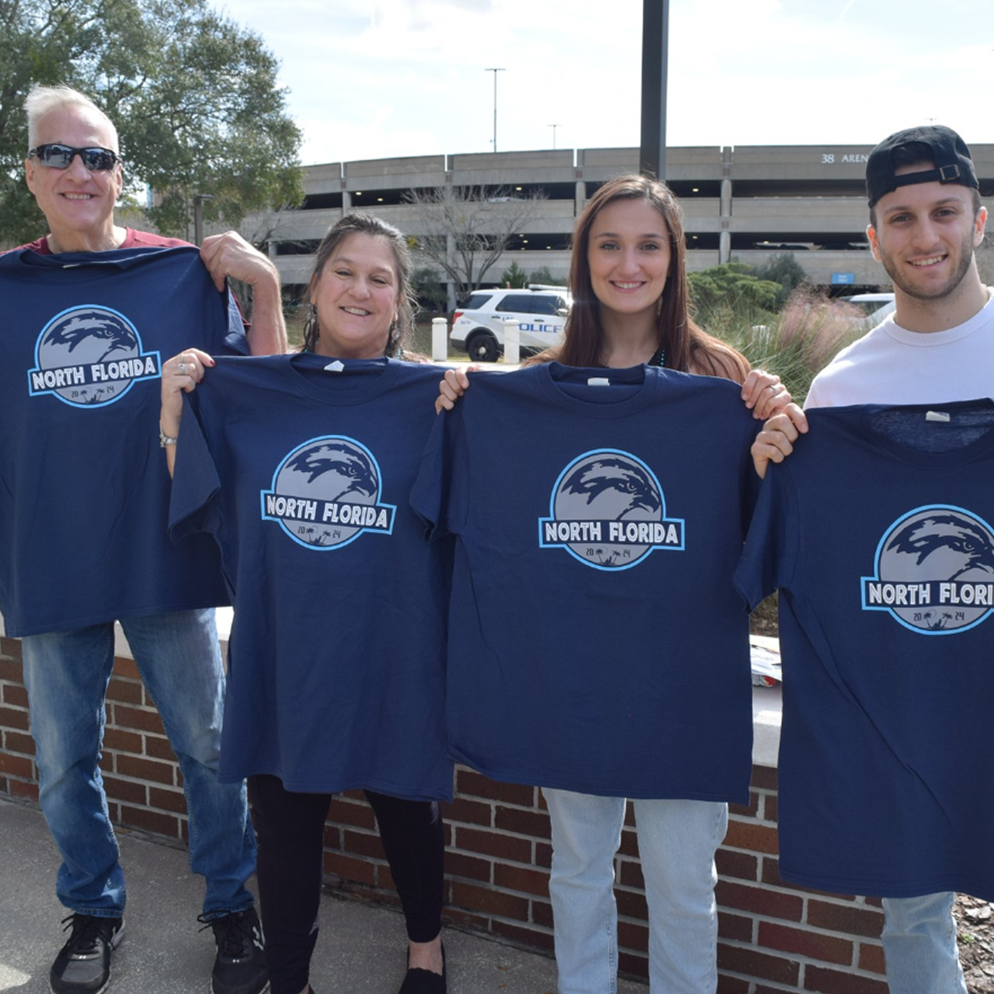 family holding up their homecoming shirts