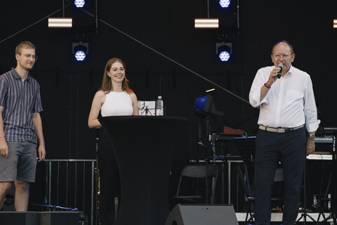 Blick auf die Bühne. Bürgermeister Christian Specht spricht in ein Mikrofon. Neben ihm stehen die AStA-Vorsitzenden.