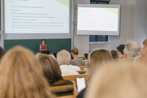 Blick aus dem Auditorium in Richtung Hörsaalpult, an dem Prof. Dr. Tabea Bucher-Koenen steht und spricht.