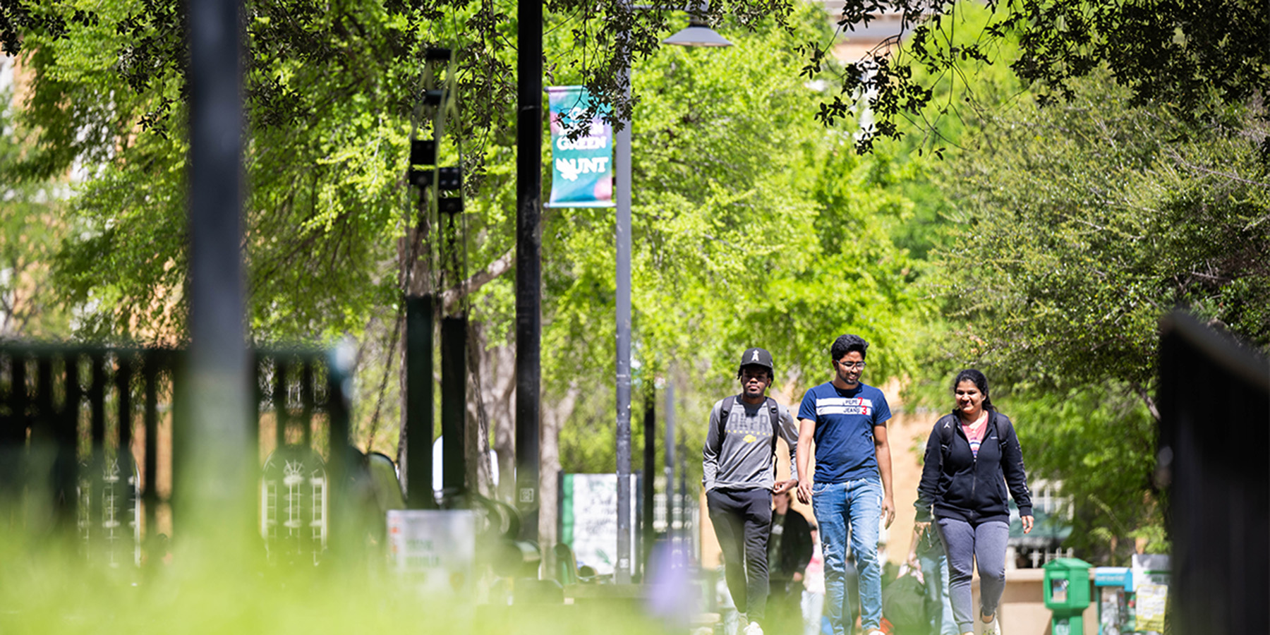 Three students walking around a college campus.