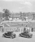 Miniature gold course with 2 vintage cars in foreground