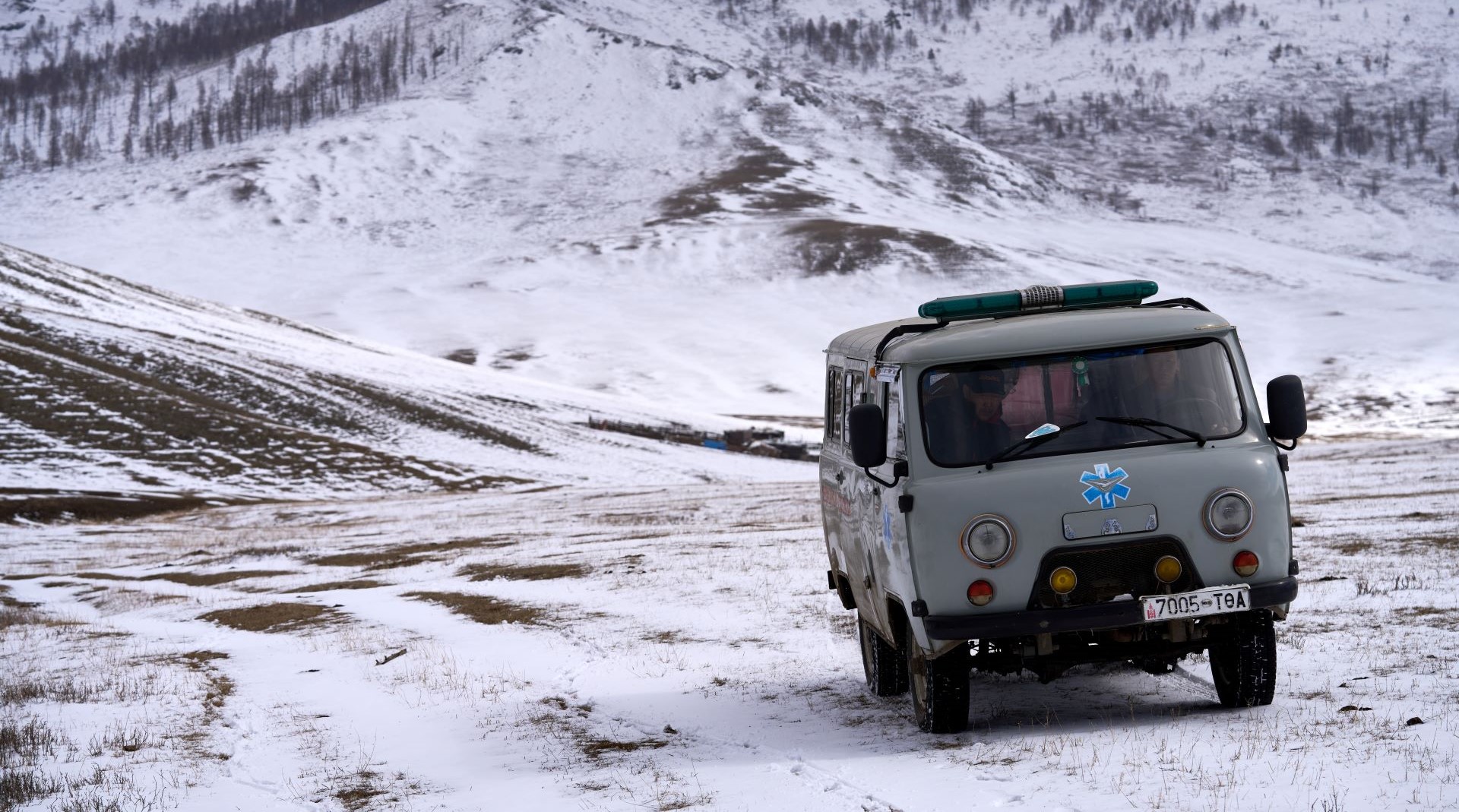 An ambulance in Mongolia drives through snow