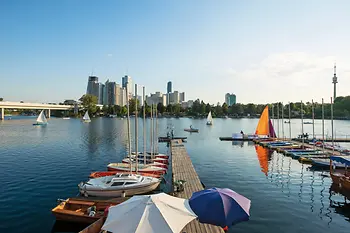 Giornata estiva sul Vecchio Danubio, barche in acqua, skyline di Vienna sullo sfondo