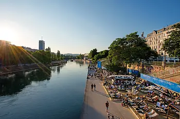 Persone sotto il sole sulle sedie a sdraio sul Canale del Danubio