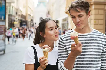 Un couple flâne en ville en mangeant une glace