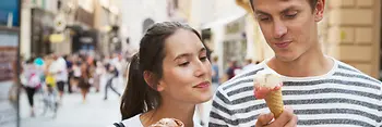 Un couple flâne en ville en mangeant une glace