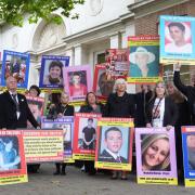 Family members of those lost after receiving treatment for mental health concerns hold up pictures outside the Lampard Inquiry at Chelmsford Civic Centre (Joe Giddens/PA)