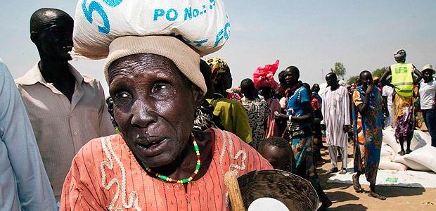 A woman carries a sack of food on March 4, 2017, in a stabilisation center in Ganyiel, Panyijiar county, in South Sudan. South Sudan was declared the site of the world's first famine in six years, affecting about 100,000 people. More than three years of conflict have disrupted farming, destroyed food stores and forced people to flee recurring attacks. Food shipments have been deliberately blocked and aid workers have been targeted. / AFP PHOTO / Albert Gonzalez Farran - AFP / Albert Gonzalez Farran