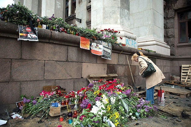 Mulher coloca flores do lado de fora de pr�dio que pegou fogo em Odessa, na Ucr�nia