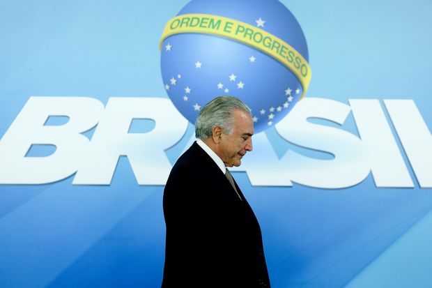 O presidente interino Michel Temer passa em frente a slogan 'Ordem e Progresso', usado por seu governo