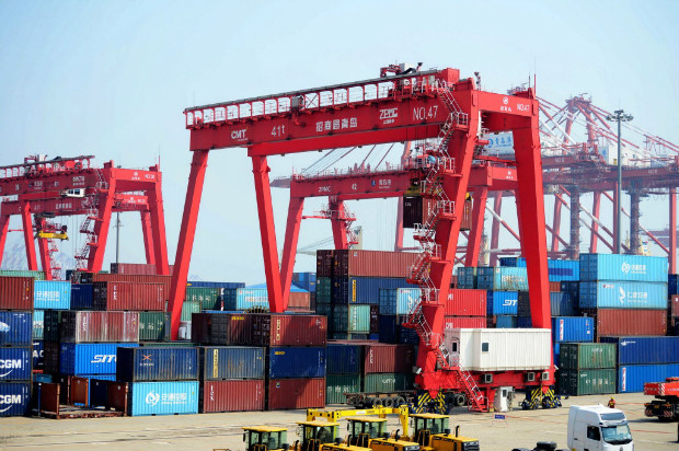 Cont�ineres s�o transportados das docas para navios no porto de Qingdao, no nordeste da China
