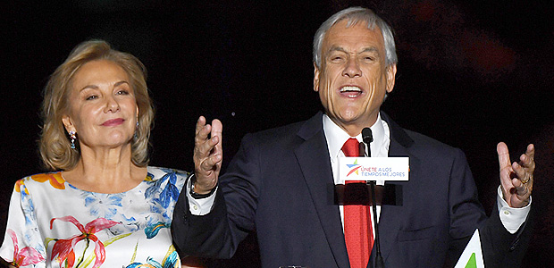 Chilean presidential candidate Sebastian Pinera (R), next to his wife Cecilia Morel, publicly celebrates his victory in Santiago after the runoff election on December 17, 2017. Conservative billionaire Sebastian Pinera will return as Chile's president, the election results show. His rival, leftist challenger Alejandro Guillier, a TV presenter turned senator who ran as an independent but was backed by outgoing center-left President Michelle Bachelet, recognized his defeat. / AFP PHOTO / Martin BERNETTI