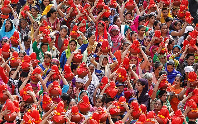 Fi�is carregam potes de barro com �gua durante prociss�o que marca o fim do festival Chaliha, na cidade de Ahmedabad (�ndia)