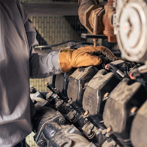 A view of a generator technician and an engine inside a generator.