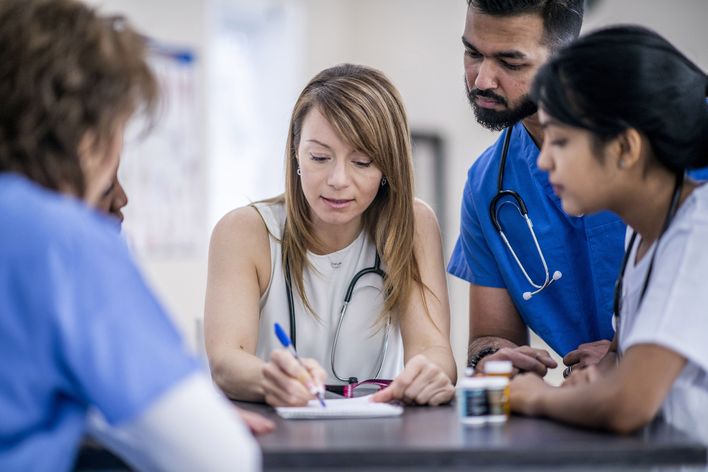 A group of clinicians studying a document on a desk