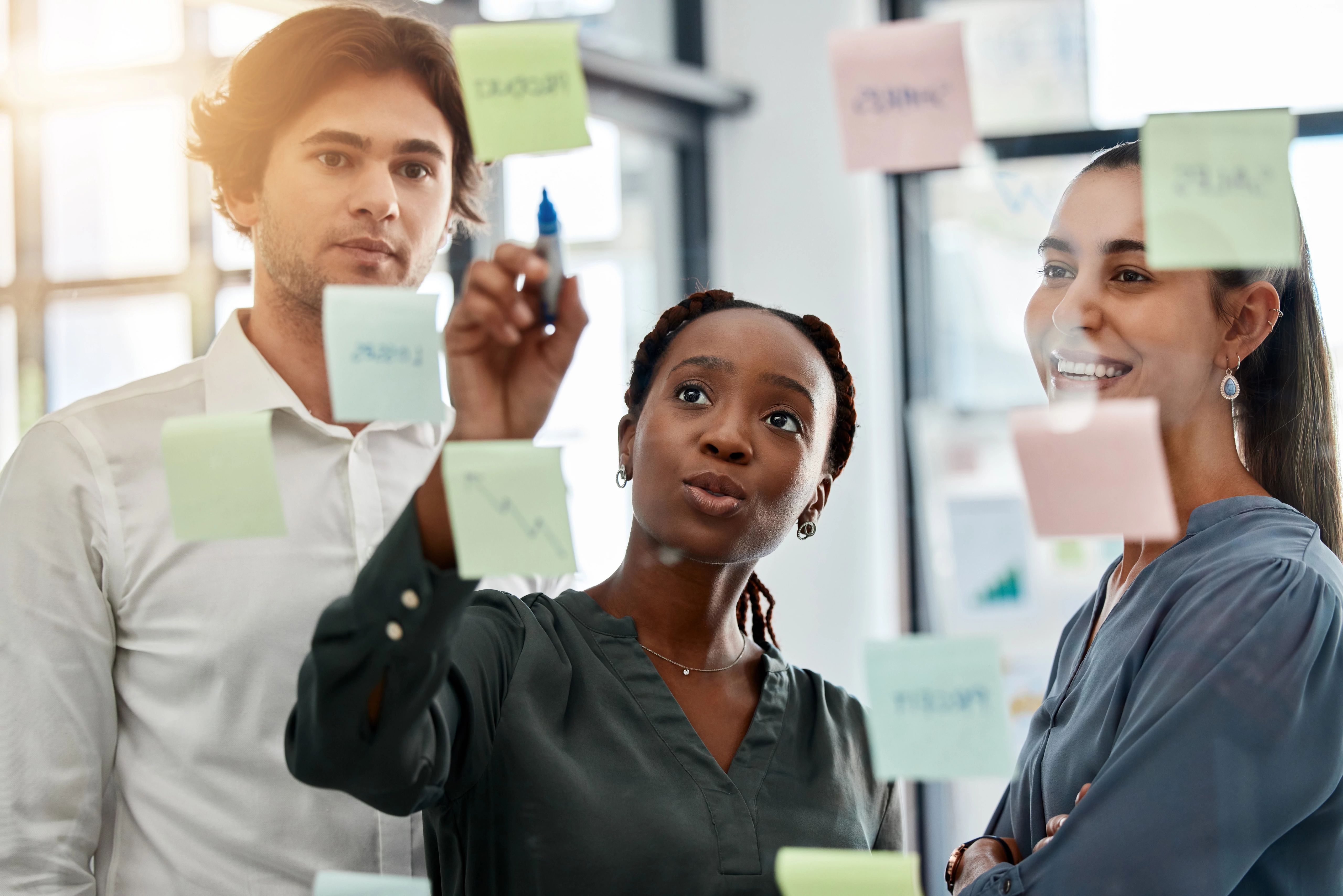 colleagues writing on post-it notes on the wall