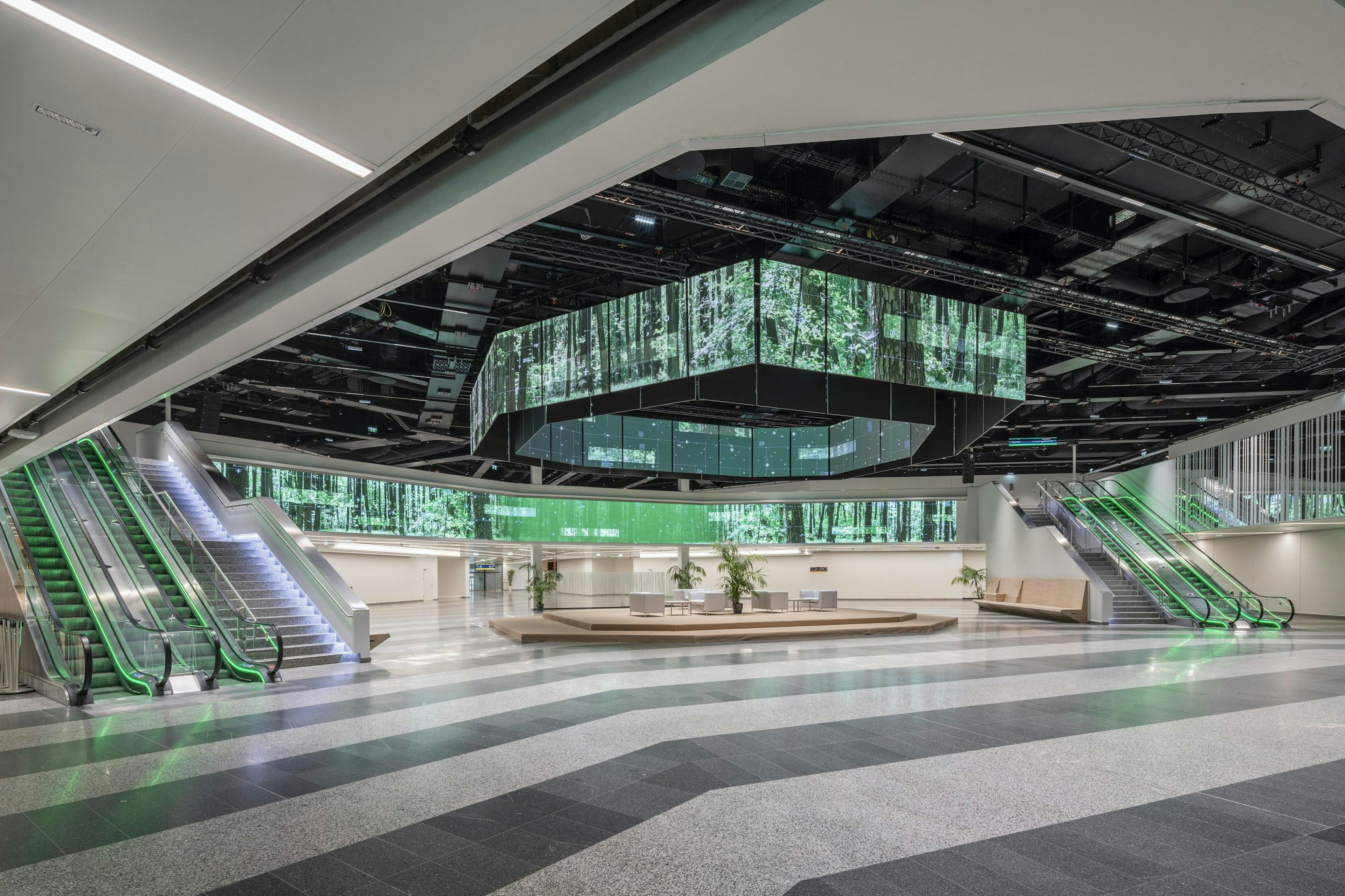 Die Eingangshalle des Austria Center Vienna mit gruen beleuchteter polySTAGE LED-Installation.