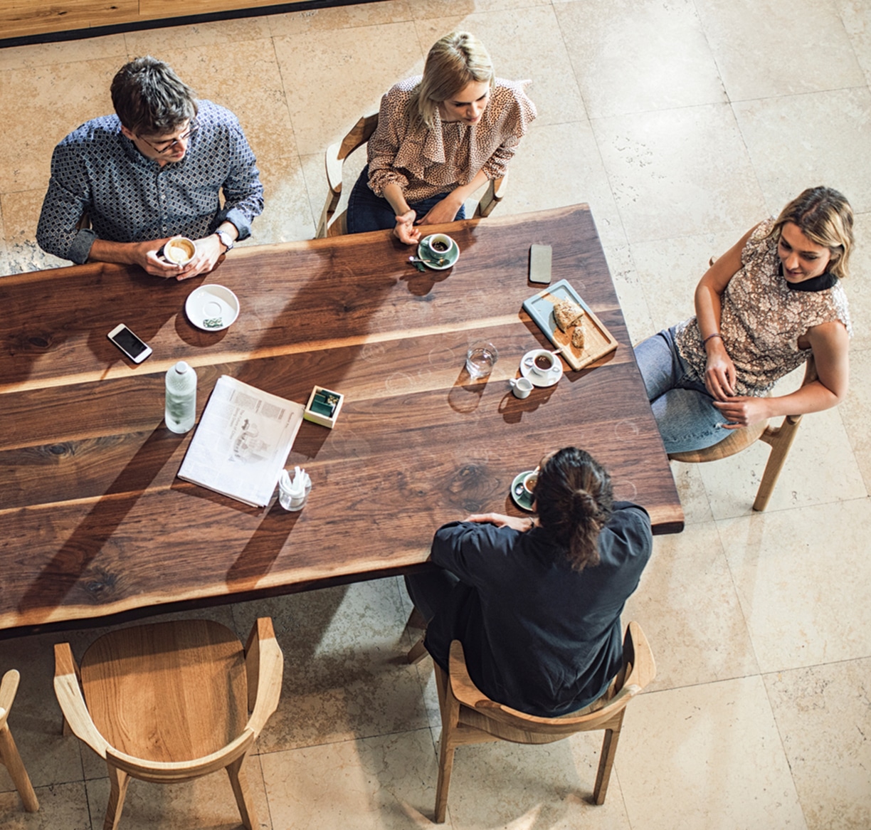 From above photo of group of young people enjoying coffee time at cafe.