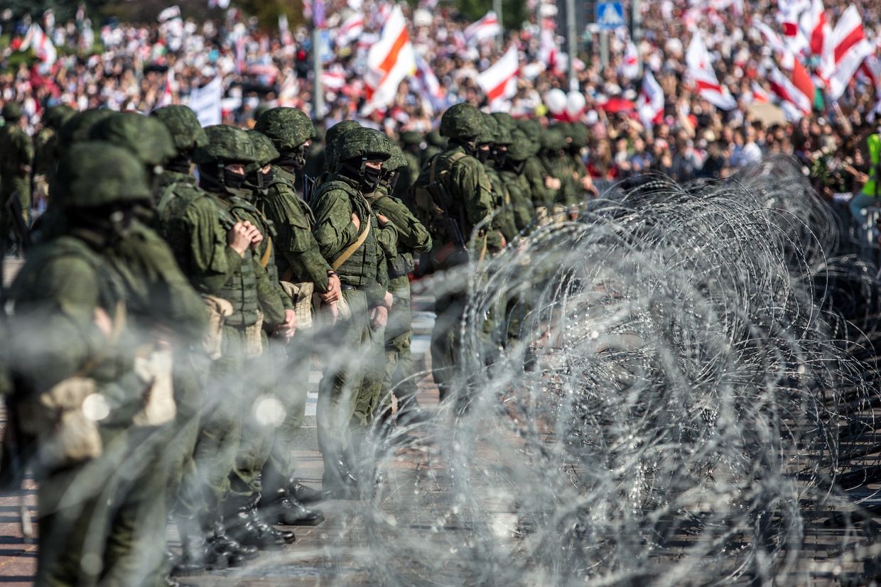 Belarusian servicemen stand behind a barbed wire fence during a protest in Minsk on Aug. 30, 2020.