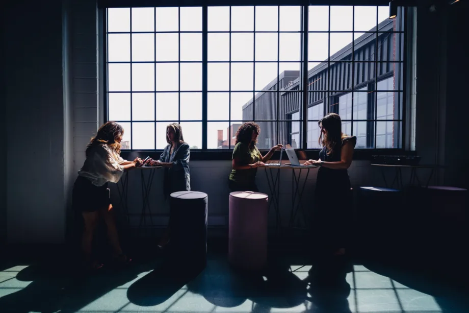Two pairs of people collaborating near windows at Nurun Canada, a digital transformation agency.