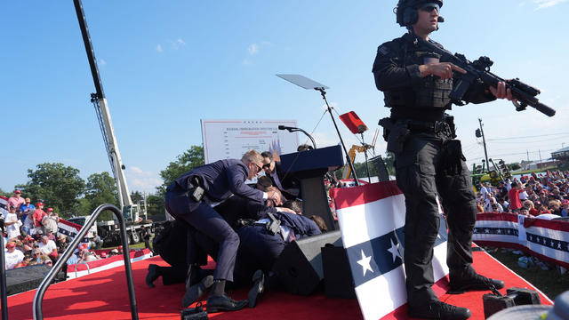 Secret service agents cover Trump on stage 