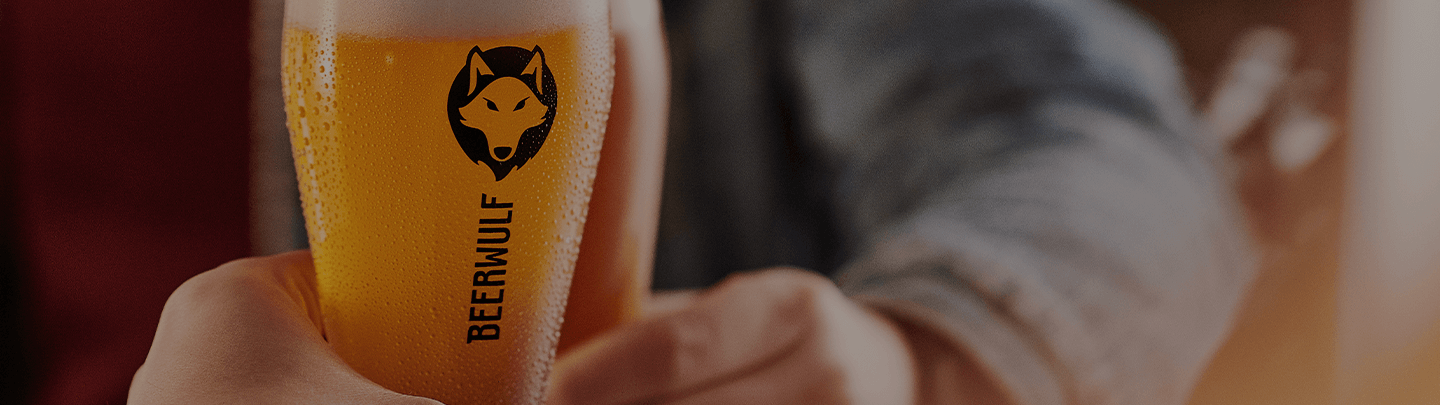 Two people cheers with fresh glasses of beer in Beerwulf beer glasses.