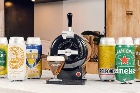 The SUB beer machine surrounded by a selection of 2L SUB kegs and a glass of freshly poured Affligem beer in front of it. 