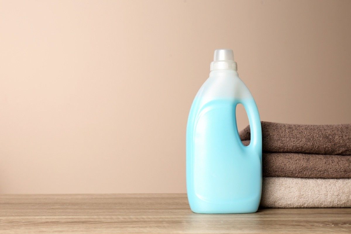 bottle of laundry detergent and stack of towels