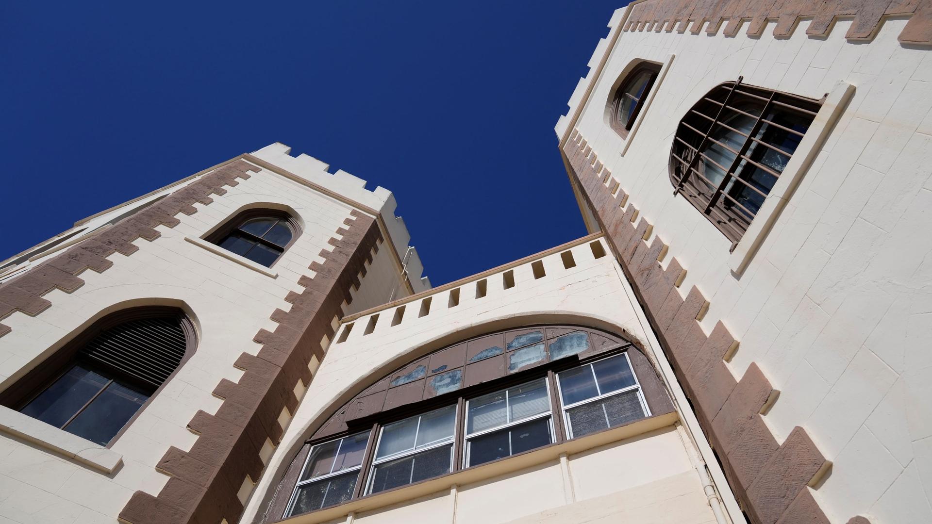 Blick auf die historischen Gebäudetürme von San Quentin, die sich in den blauen Himmel recken.