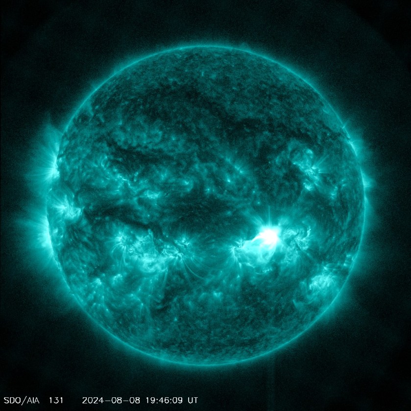  The Sun appears in shades of teal with some brighter and darker regions, set against a black background. To the lower right of center is a bright flash of white. A time stamp of 2024-08-08 19:46:09 UT appears at the bottom.