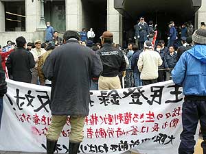 一方的記者会見に抗議する労働者