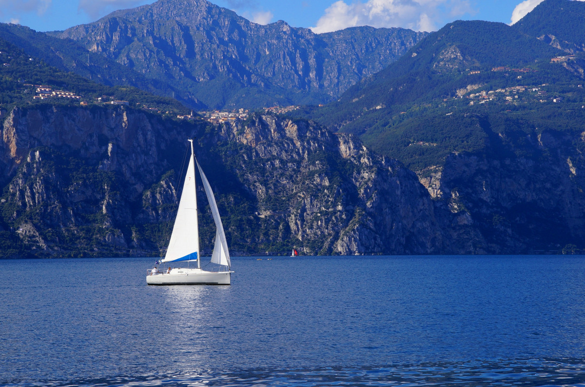 landscape, sea, water, nature, mountain, boat, lake, mountain range, reflection, vehicle, sailing, holiday, bay, italy, blue, fjord, body of water, garda, sail, watercraft, sailing boat